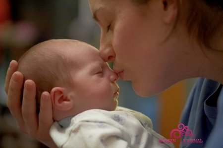 мама целует новорожденного